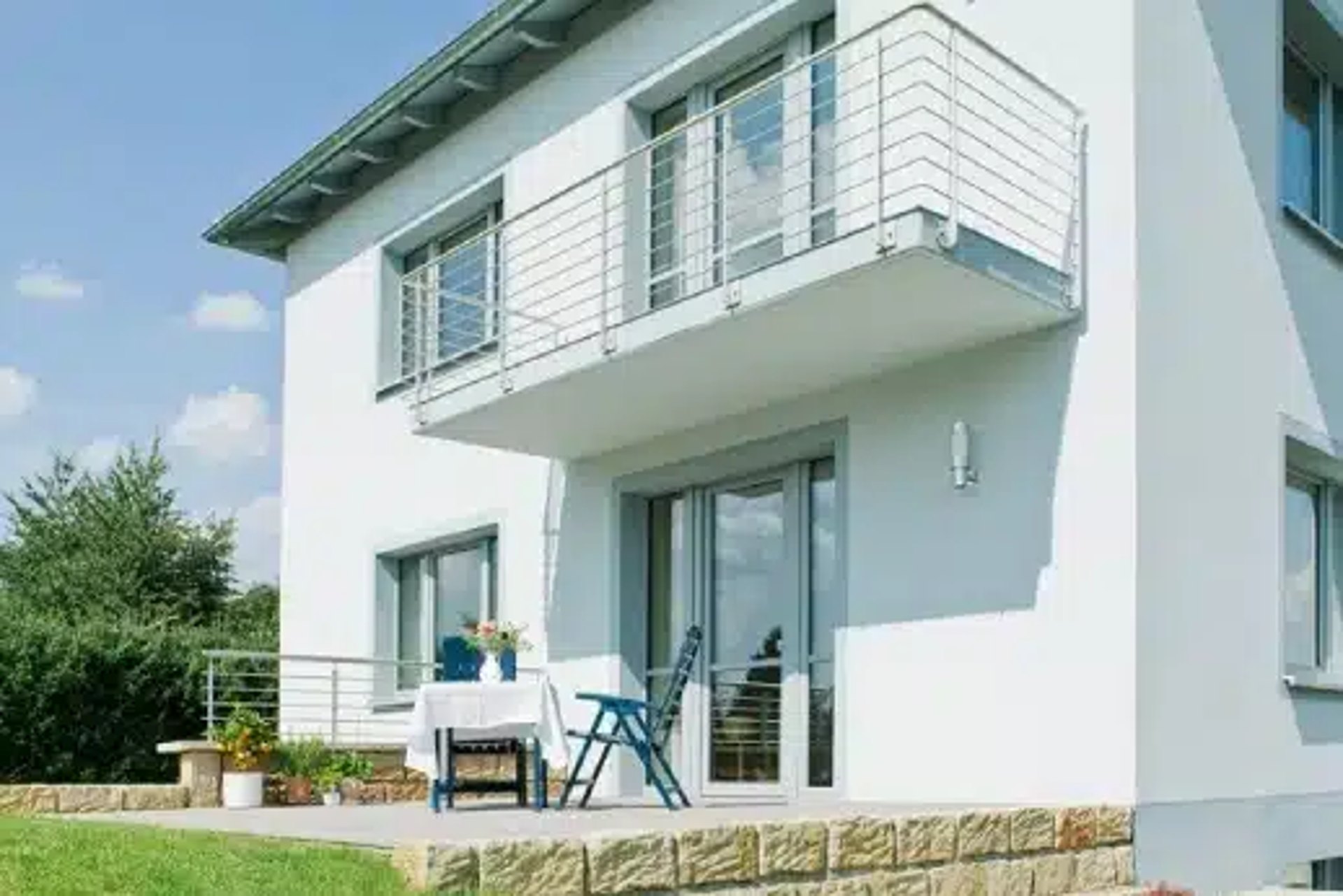 Weißes Haus mit neuen Fenstern, Balkon und Terrasse