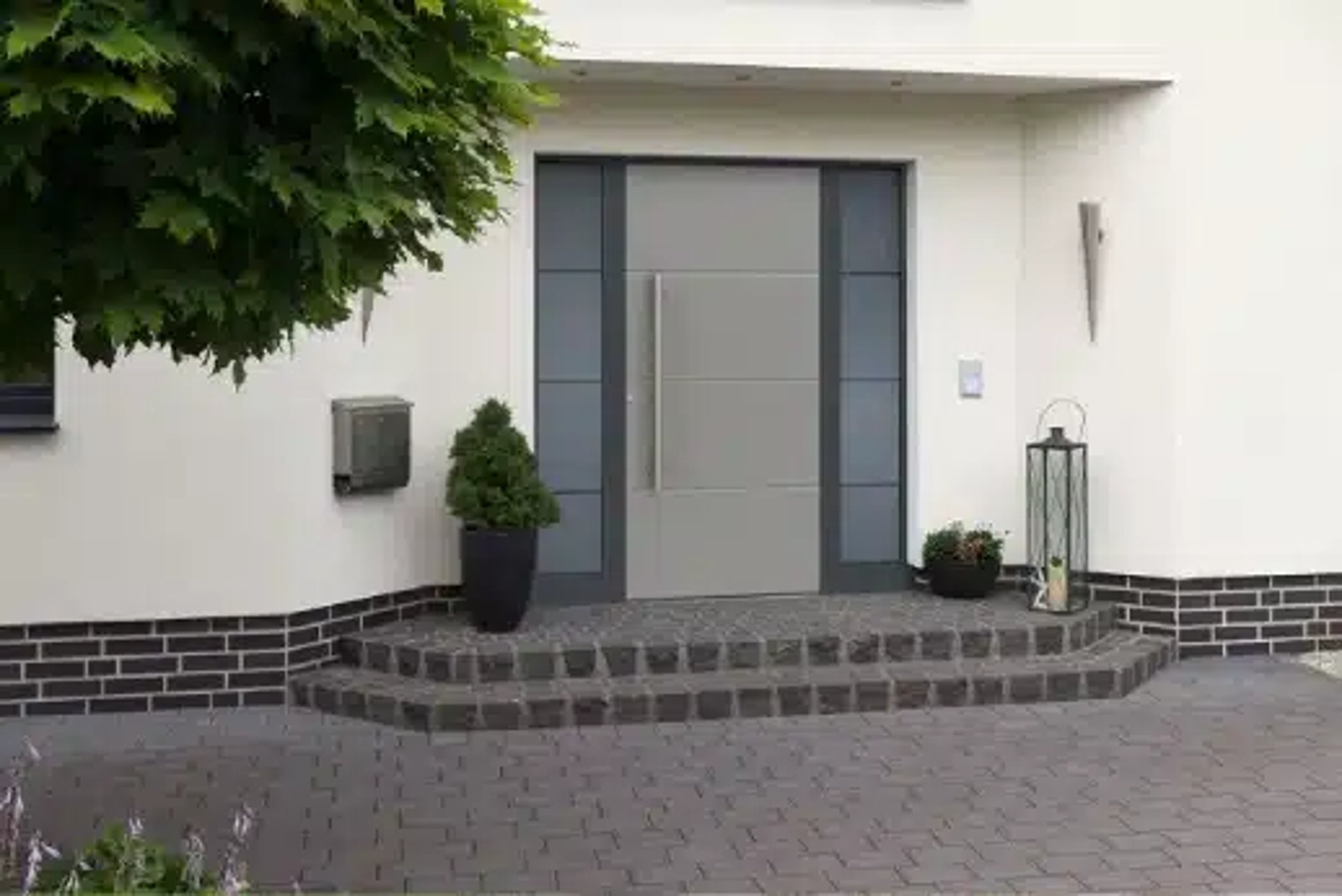 Moderne Haustür aus grauem Metall und Glas